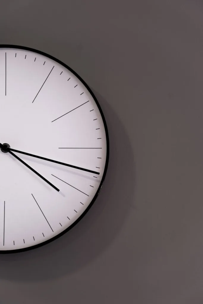 white analog wall clock at 11 00